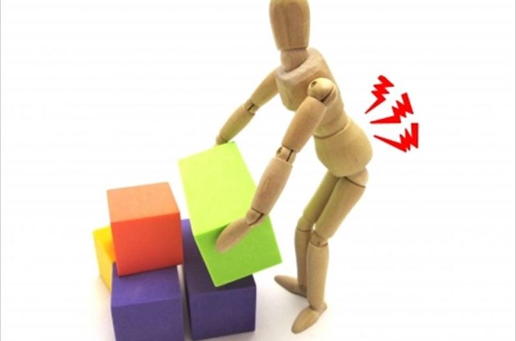 重いものを持って腰を痛めている模型